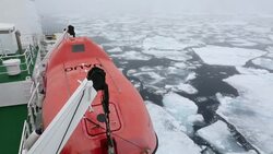 The Russian research vessel, AkademiK Sergey Vavilov an ice strengthened ship on an expedition cruise to Northern Svalbard, with clients on the prow at over 80 degrees north in rotten sea ice, some 550 miles from the North Pole. Stock Footage