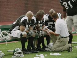 MS, American football coach talking to players on bench, Staten Island, New York, USA Stock Footage