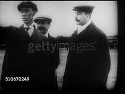 1909: WRIGHT BROS AEROPLANE COMPANY: Wilbur Wright placing wheel under airplane wing, horse towing over field, Wilbur talking w/ Hart O. Berg & unidentified man, CU Brother Orville, VS Airplane demonstration, men turning propellers, airplane in flight Instructional Video