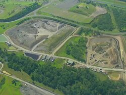 MS AERIAL TS DS View of dumping ground with traffic moving on road / Sydney, New South Wales, Australia Stock Footage