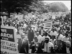 B/W August 28, 1963 high angle large crowd with signs marching on wide street / March on Washington / newsreel Stock Footage