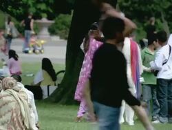 WS Family talking and then walking through busy park / London, England, United Kingdom Stock Footage