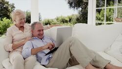 Happy senior couple shopping online on patio sofa Stock Footage
