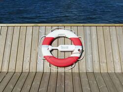 Life belt hanging on wooden pier or boat at midday Stock Footage