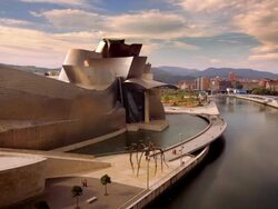 Wide shot Pedestrians walking along promenade outside Guggenheim Museum Bilbao/ Bilbao, Vizcaya Province, Spain Stock Footage