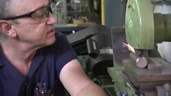 A machinist operates an aluminum filing and sealing machine. Stock Footage