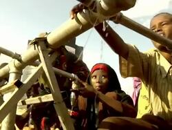 Children getting water from tap at refugee camp Stock Footage