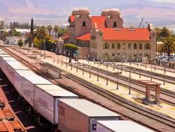 WS T/L ZI freight train carrying shipping containers pulls through rail yard near historic train station building / San Bernadino, California, USA Stock Footage