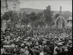 1946: OAXACA DANCING: CU 'Oaxaca' festivities poster. WS Mexicans in celebration, parade, street. WS Mexicans in feather & Indian-like costumes performing Aztec, Mayan dance. CU Father carrying girl in crowd, watching. WS Dancers. Mexico Instructional Video