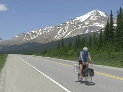 WS Bicycle rider and traffic moving on road through Icefields Parkway near Bow Lake / Banff Nationalpark, Alberta, Canada Stock Footage