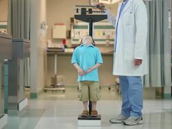 Doctor weighing child patient Stock Footage