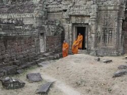 WS Buddhist monks walk out of an ancient temple in Angkor Wat carrying alms bowls to collect offerings / Siem Reap, Cambodia Stock Footage