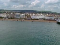 Aerial along the coast of Eastbourne / over Eastbourne Pier / East Sussex, England Stock Footage