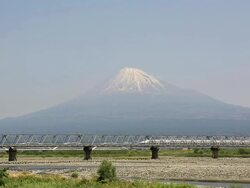 WS View of Bullet train Shinkansen passing on bridge in front of snow capped Mount Fuji / Fujigawa, Shizuoka Prefecture, Japan  Stock Footage