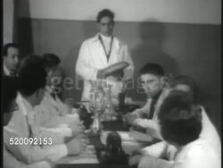 1935: DRAMATIZATION: Moscow USSR Central Committee Meeting w/ male standing, showing loaf of bread to other Committee members. Communism, Russia. Instructional Video