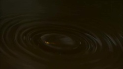 Water drips into a dark pool creating concentric ripples. Stock Footage