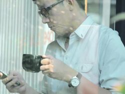 Young man using mobile phone and drinking coffee,Steadycam shot Stock Footage