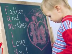 boy draws a card for parents Stock Footage