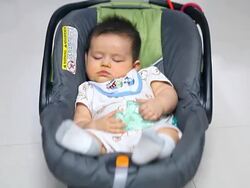 Portrait of baby boy sleeping in carseat. Stock Footage