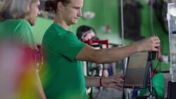Bike shop manager swipes credit card at sales counter and instructs new employee at register Stock Footage