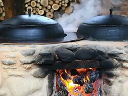 CU Shot of Furnace (facility to heat room or Caldron) with fire and Caldron (Korea's traditional cooking utensils used to make rice) gushing smoke / Chuncheon, Gangwondo, South Korea Stock Footage