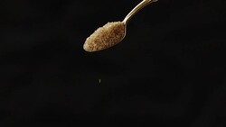 SLOMO CU Brown Sugar Pouring Down from Wooden Spoon Stock Footage