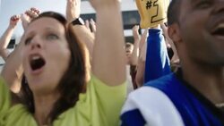 Anxious stadium crowd cheers at football game, jumps to feet Stock Footage