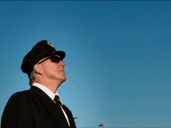 M/S airline pilot steps into frame, airplane passes overhead: ANA Boeing-777 Stock Footage