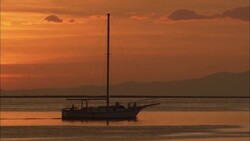 A sailboat glides through Manila Bay at sunset. Stock Footage