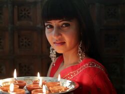 CU Portrait of young woman holding tray of small oil lamps  / Singapore Stock Footage