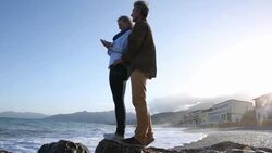 Couple take smart phone pic on beach, sunrise Stock Footage