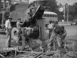 1953: CAMDEN, SOUTH CAROLINA: VS African-American males working, shoveling wet concrete in blocked off area by U.S. Highway 1 in city, pouring concrete, group smoothing dirt for sidewalk, MS Circular excavator plowing, lifting & dumping dirt. Instructional Video