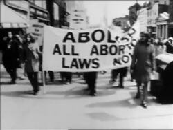 B/W late 1960s women marching with "Abolish All Abortion Laws Now" banner / newsreel Stock Footage