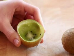 Girl is eating kiwi with a spoon Stock Footage