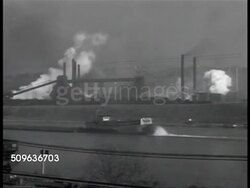 1941: NORTHERN USA: WS Industrial area w/ white smoke pouring from stacks, paddle boat on water FG. Woman walking up sidewalk crossing Pulaski Street. MS Pulaski & Kossuth Street signs (Bridgeport Connecticut), man in coat walking up sidewalk. Stock Footage