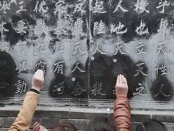 CU ZO Pilgrims touch Chinese character on wall pray for good luck and wealth during Chinese Lunar New Year at Taoist temple / xi'an, shaanxi, china Stock Footage