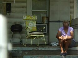 Woman sits on porch Stock Footage
