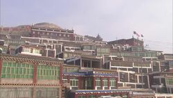 A Tibetan village built on tiers is seen on a mountainside. Stock Footage