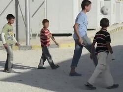 Syrian Civil War refugee boys play soccer in Jordanian refugee camp Stock Footage