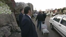 An inspector walks through a farmers' market, talking with vendors offering bulk quantities of vegetables. Stock Footage