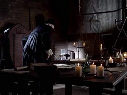 Nostradamus sets his book on the candlelit table, gets up, and walks away. Stock Footage