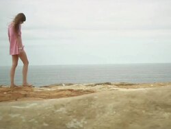 WS PAN Woman walking on ridge with sea in background / Cape Kiwanda, Oregon, USA Stock Footage