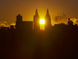 Shot of an orange sun rising between the San Remo Apartments in the Midtown Manhattan Skyline. Stock Footage