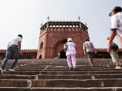 LS Tourists climbing steps into the Jama Masjid, a Muslim mosque / Delhi, Punjab, India Stock Footage