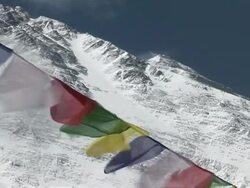 MS CU Colorful prayer flags blowing in wind beneath snowy Mt. Everest Stock Footage