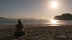 Brazilian girl stretching on Copacabana Beach raises arms, bends forward, and leans side to side in the sun and sand Stock Footage