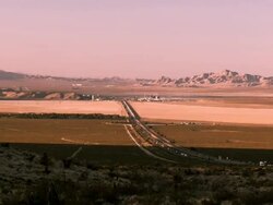WS ZI Mojave desert with mountain range and Interstate 15 traffic through casino resort Primm at Nevada California state line / Primm, Nevada, USA Stock Footage