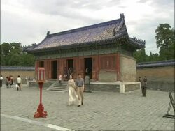 Couple walk to camera across courtyard of Temple of Heaven, Beijing, China Stock Footage