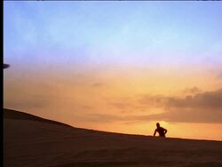 low angle man running up hill towards camera + jumping at sunset Stock Footage