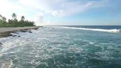 Moving over coastline and breaking waves on Manra Atoll Stock Footage